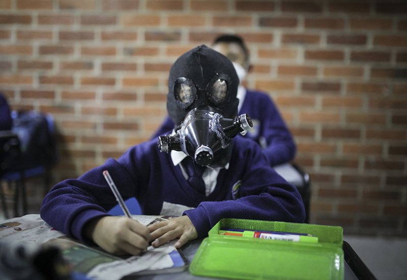 Học sinh đeo khẩu trang tự chế tại một trường học ở Soacha, Colombia hôm 11/3. Họ làm khẩu trang bằng mọi thứ có thể, từ chai nhựa đến lá chuối với hy vọng bảo vệ bản thân khỏi virus.
