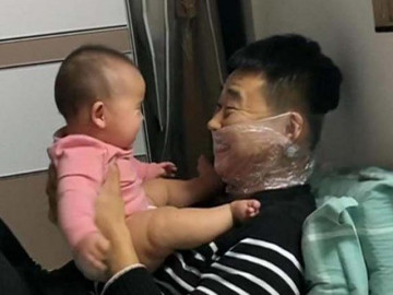Ông bố cuộn nilon quanh miệng để chạm môi con, lý do khiến ai cũng cảm động