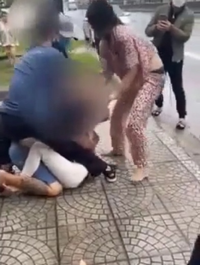 Người vợ mặc bộ quần áo hoa lao vào đánh đập nhân tình của chồng một cách dã man. (Ảnh cắt từ clip)