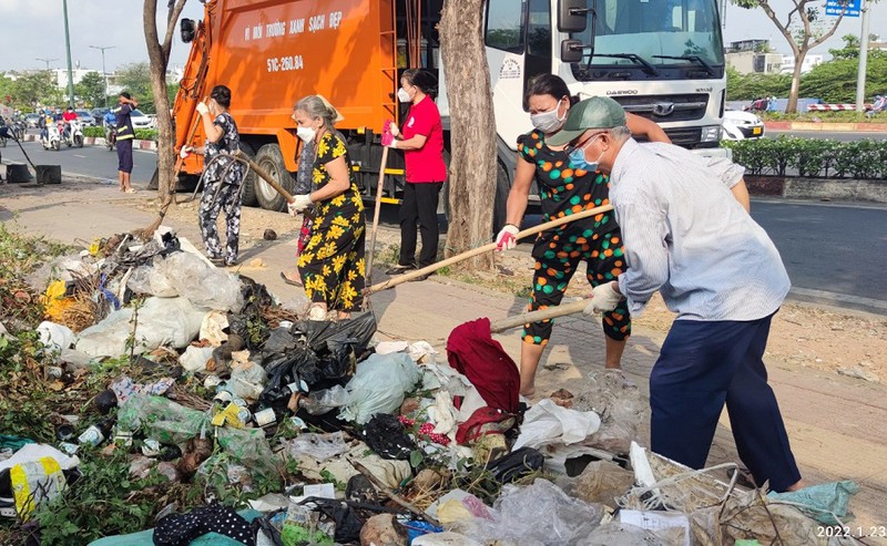 Người dân phường 13, quận Bình Thạnh, TP.HCM dọn rác tại đường Phạm Văn Đồng. Ảnh:NGUYỄN HIỀN