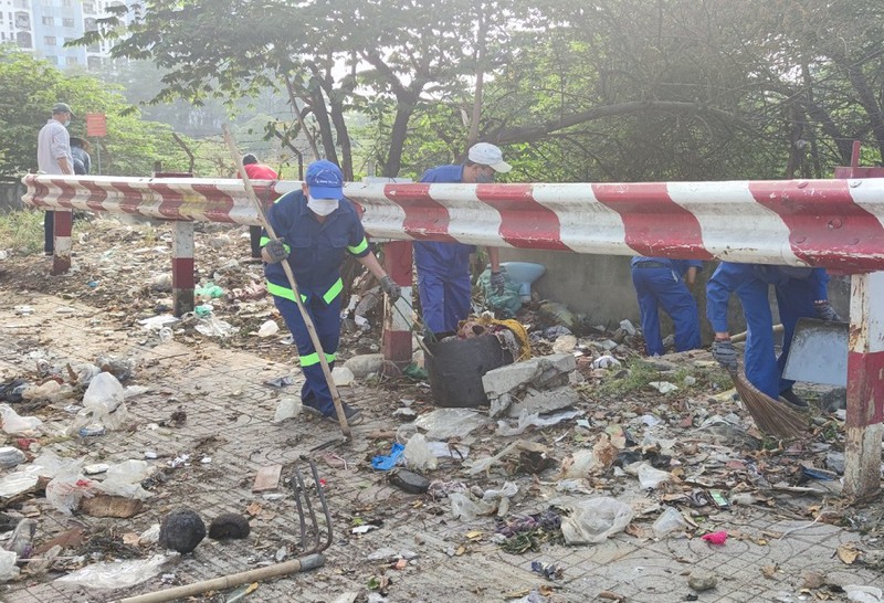 Rác thải dưới chân cầu Rạch Lăng đang được dọn dẹp. Ảnh: NGUYỄN HIỀN