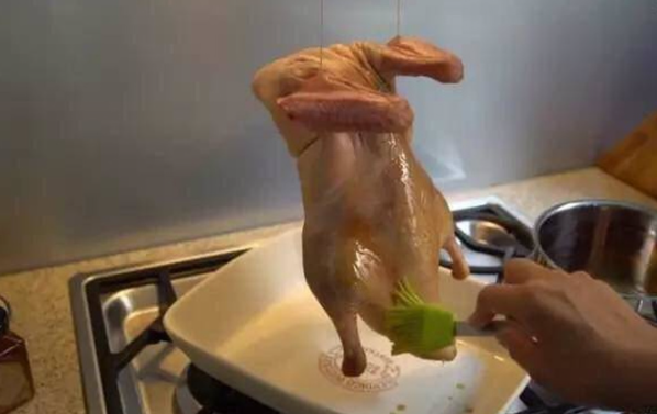 Phết nước sốt ướp bên ngoài con vịt, treo vịt lên cho vịt khô ráo hoàn toàn