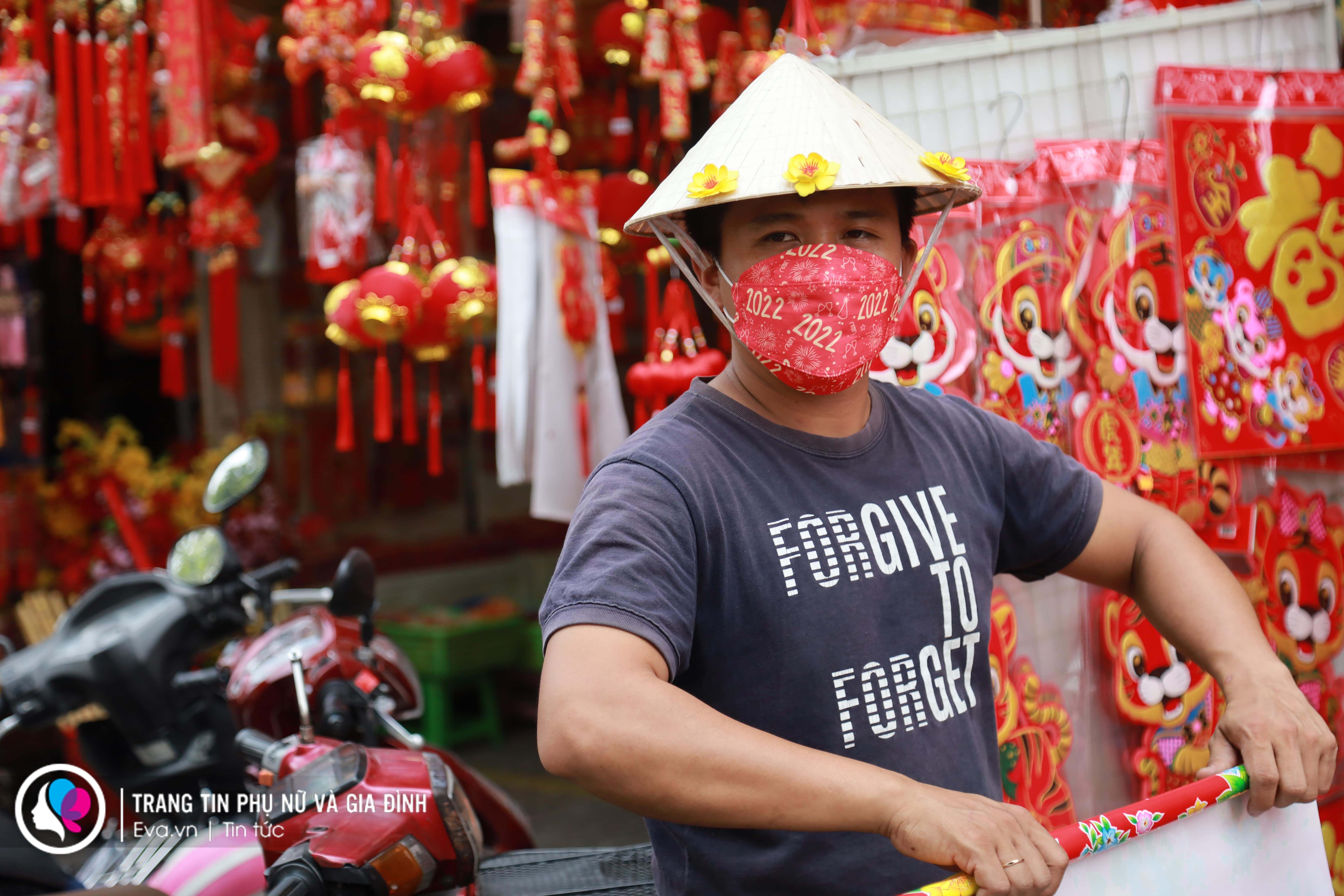 Chủ cửa hàng tranh thủ ra ngoài mời khách, anh cho biết đã đặt chiếc khẩu trang mang sắc xuân này qua mạng và được rất nhiều khách hàng hỏi chỗ mua