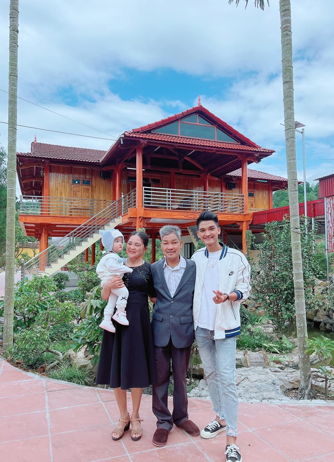 Mạc Văn Khoa và con gái chụp ảnh kỷ niệm cùng bố mẹ trước ngôi nhà.