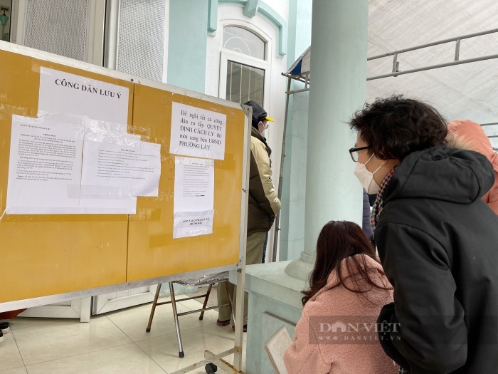 Người dân đọc thông báo của Trạm Y tế phường Hoàng Liệt. Ảnh: Gia Khiêm