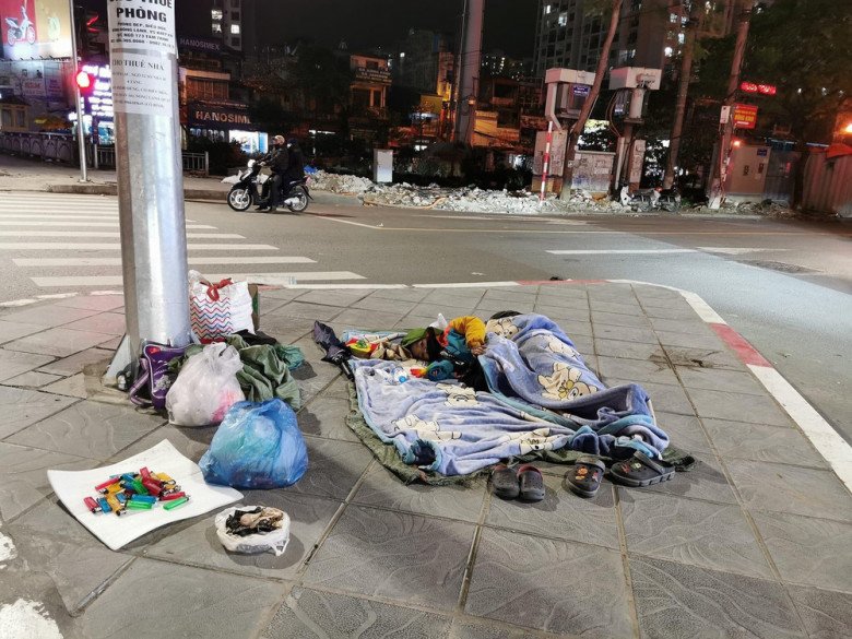 Hai em bé nằm co ro giữa ngã tư dưới tiết trời lạnh giá.