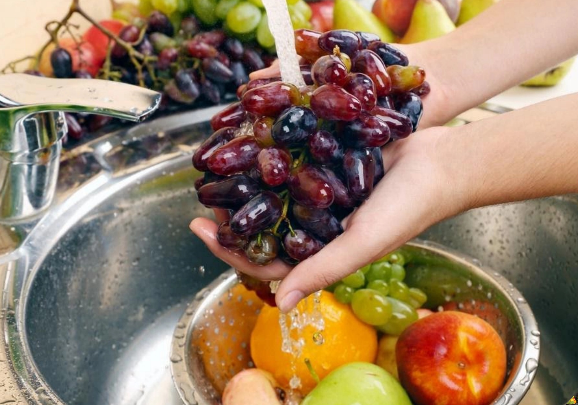 A woman carefully cleaning and drying fruits for the five-fruit tray