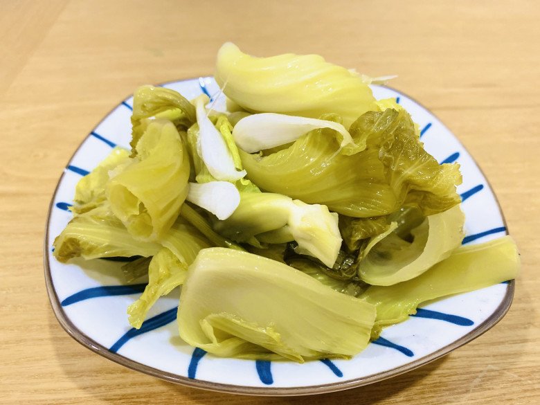 A jar of pickled cabbage with a fork and a plate of rice