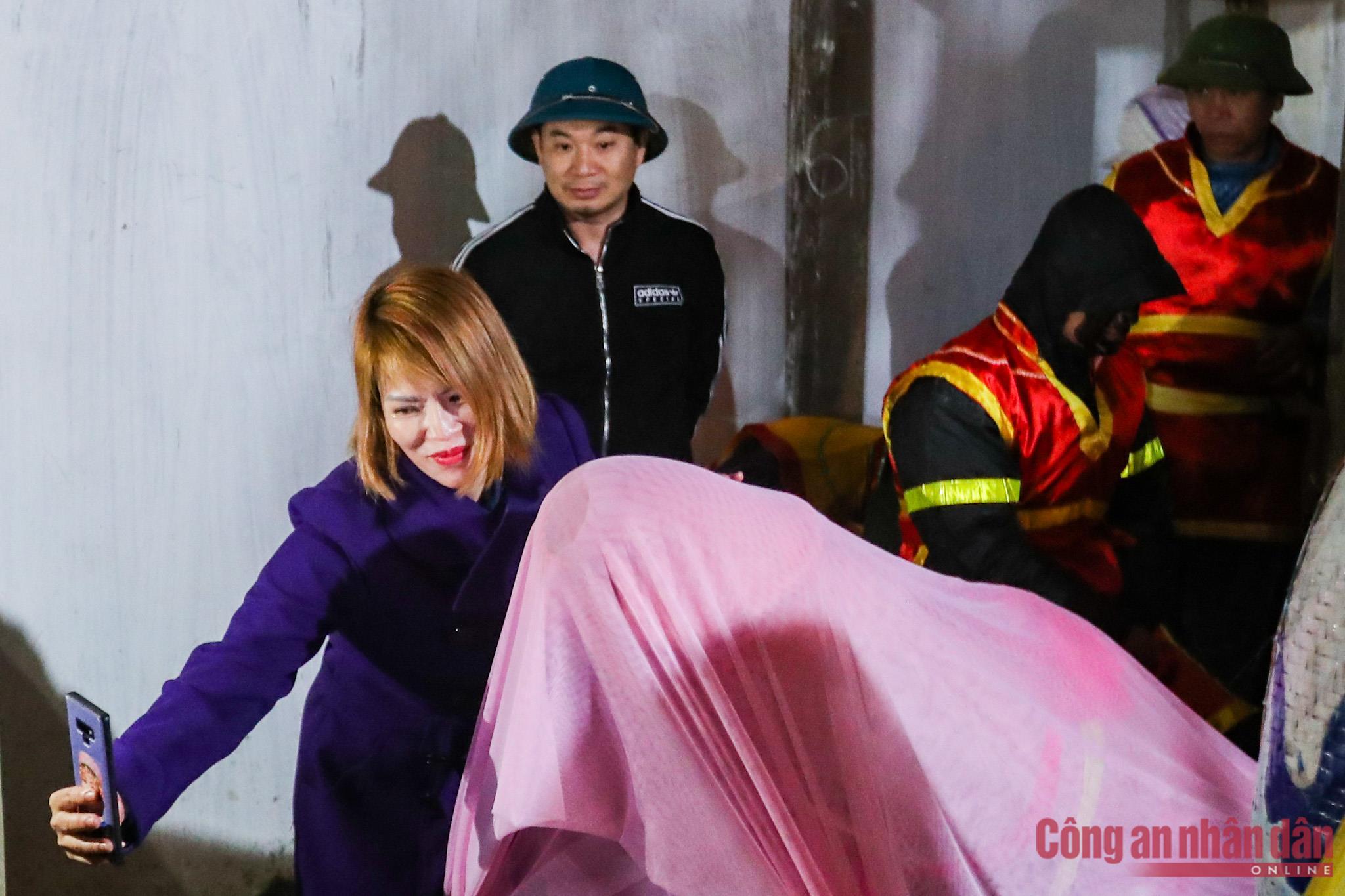 Một du khách chụp ảnh check in cùng Tàng thinh tại đình làng Trấn Yên trước khi lễ rước diễn ra.