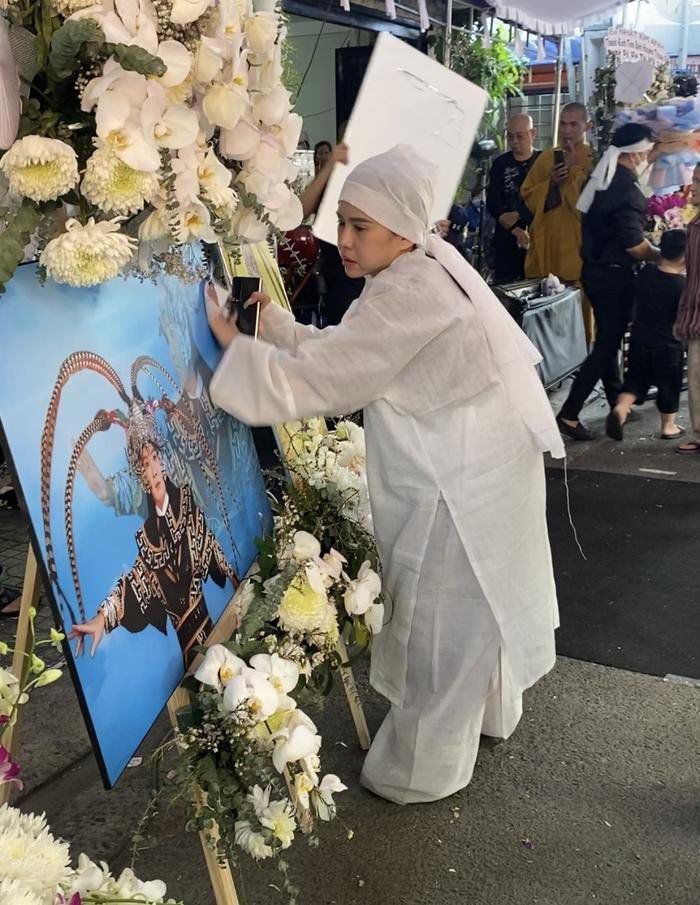 Hình ảnh nữ nghệ sĩ nâng niu, lau chùi cẩn thận từng bức di ảnh của Vũ Linh khiến dân tình đau xót.