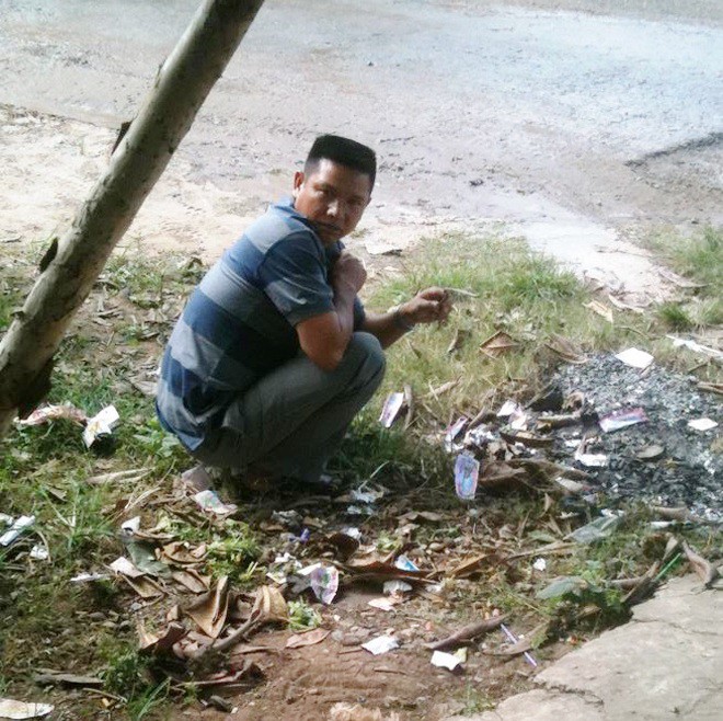 Anh H thẫn thờ ngồi bên đống rác đã được đốt.