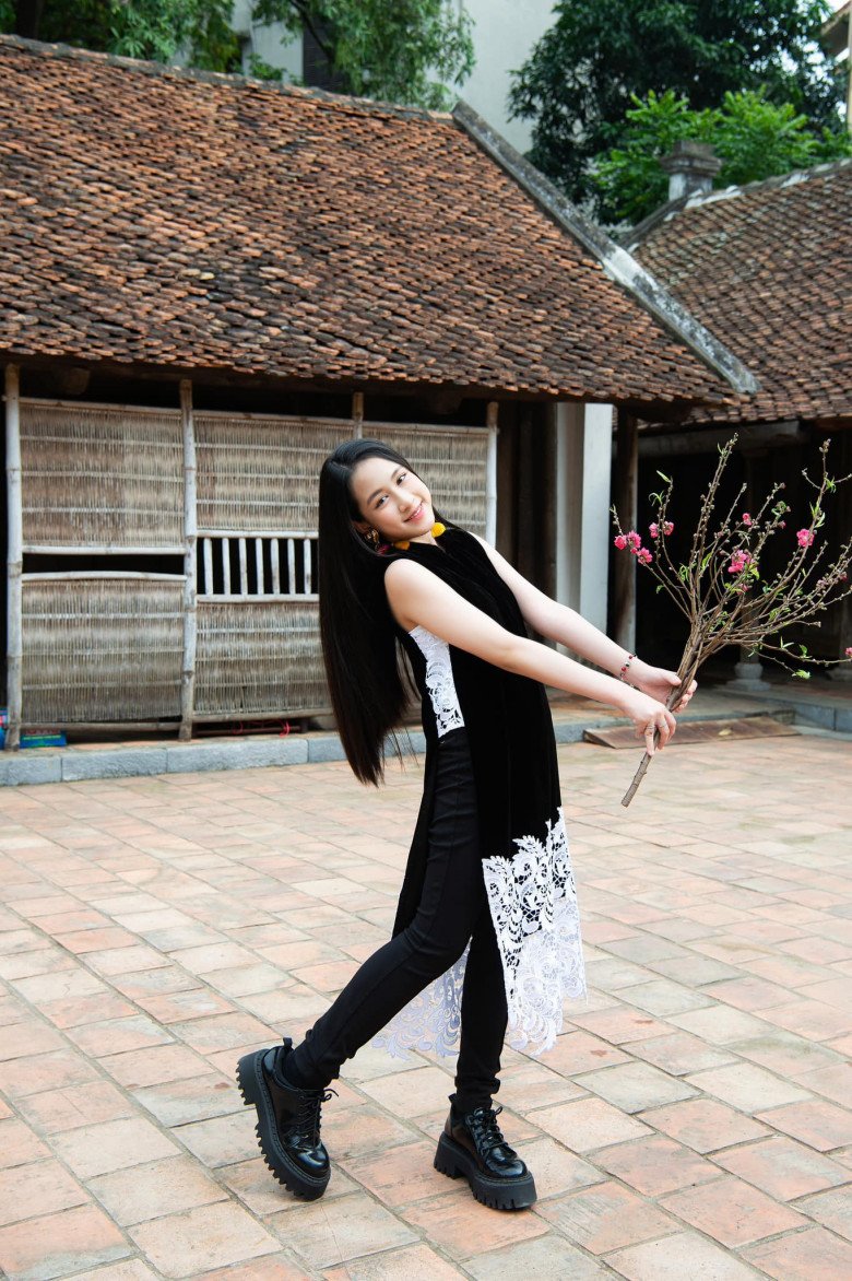 Cô bé tên là Kỳ Uyên. Cùng mẹ lên sóng, Kỳ Uyên diện áo dài cách tân sát nách màu đen phối ren trắng ở phần tà áo và bên mạn sườn. Chốt hạ tổng thể bằng quần skinny và giày boots đen cá tính và có phần hầm hố nhưng toát lên vẻ năng động đúng lứa tuổi của bé.