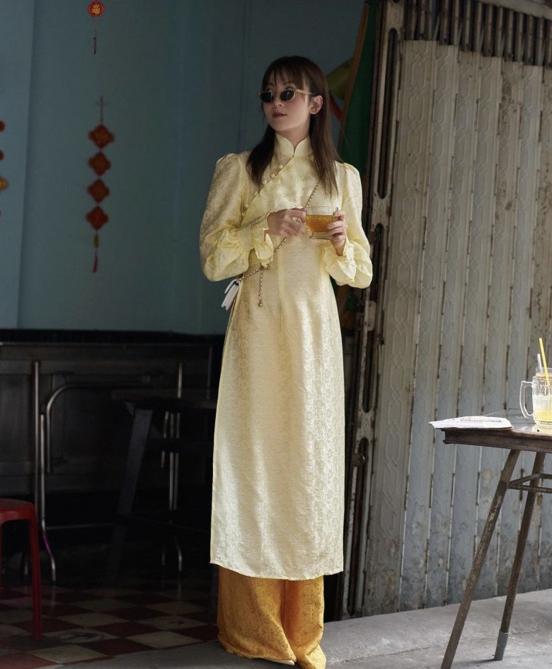 Trong khi cô chị nổi bật với sắc hồng thì cô em Yến Nhi lại hướng về phong cách vintage nhờ áo dài cổ trụ màu vàng. 
