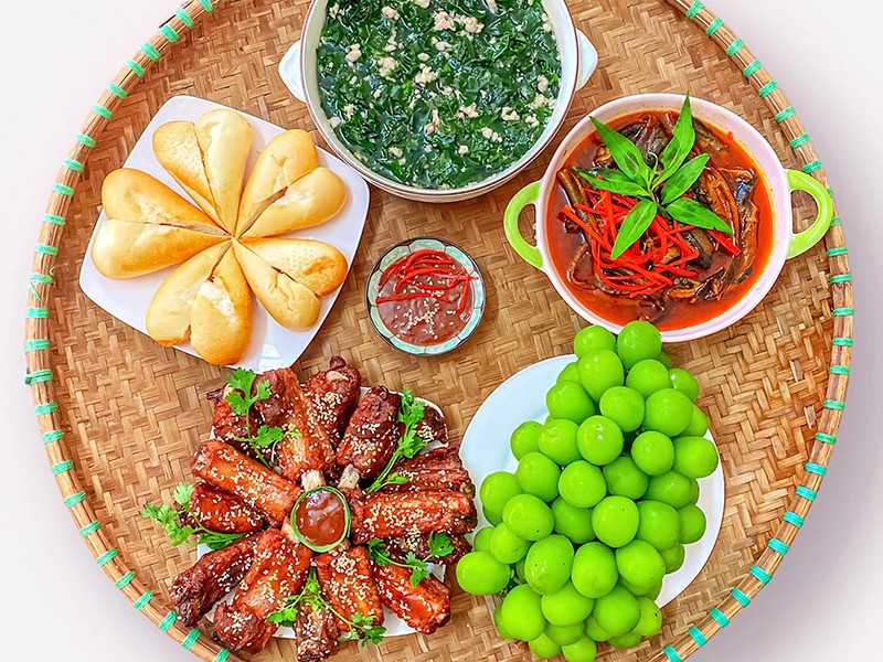 Bữa ăn ngon miệng này gồm có: Sườn chiên, canh rau ngót thịt băm, súp lươn ăn kèm bánh mì, nho tráng miệng. (Ảnh: Linh Phạm).
