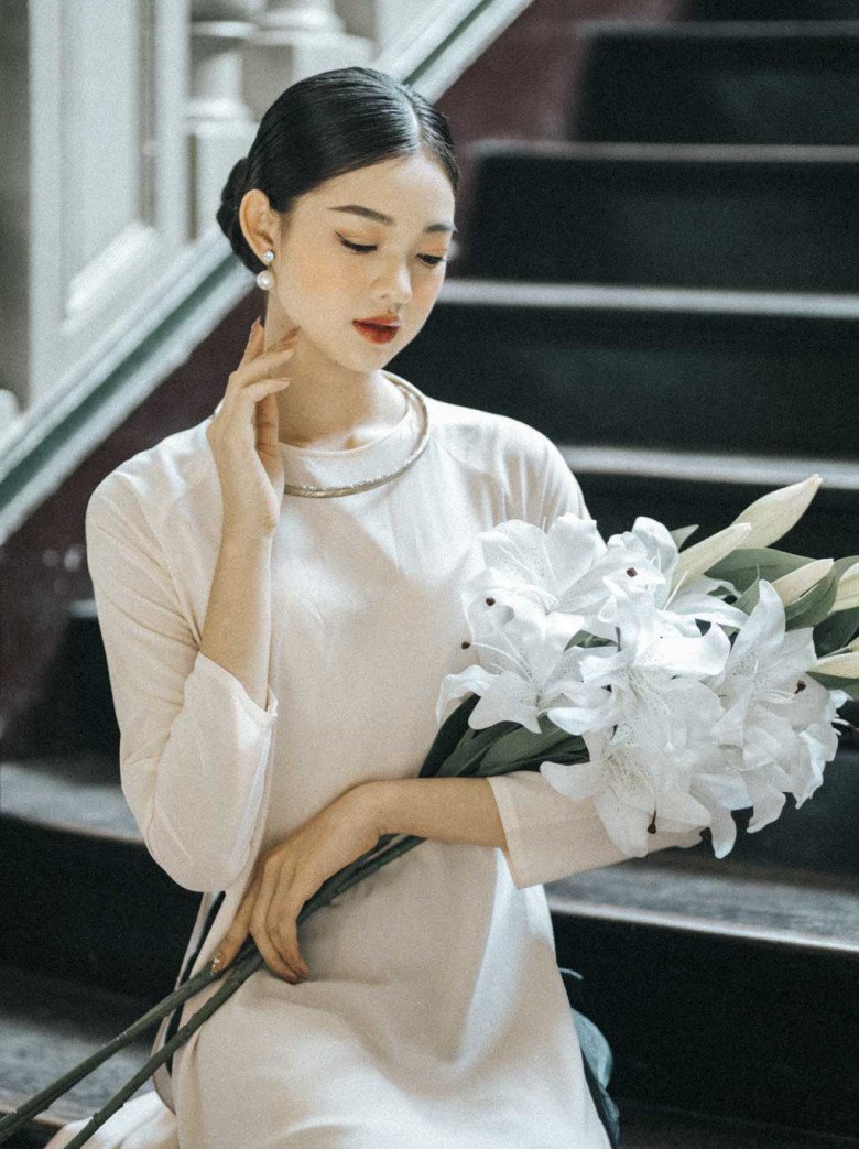 Tà áo dài truyền thống được tô điểm thêm một chút má hồng cam đào trên đôi gò má cao cao của nàng trông vô cùng nữ tính.