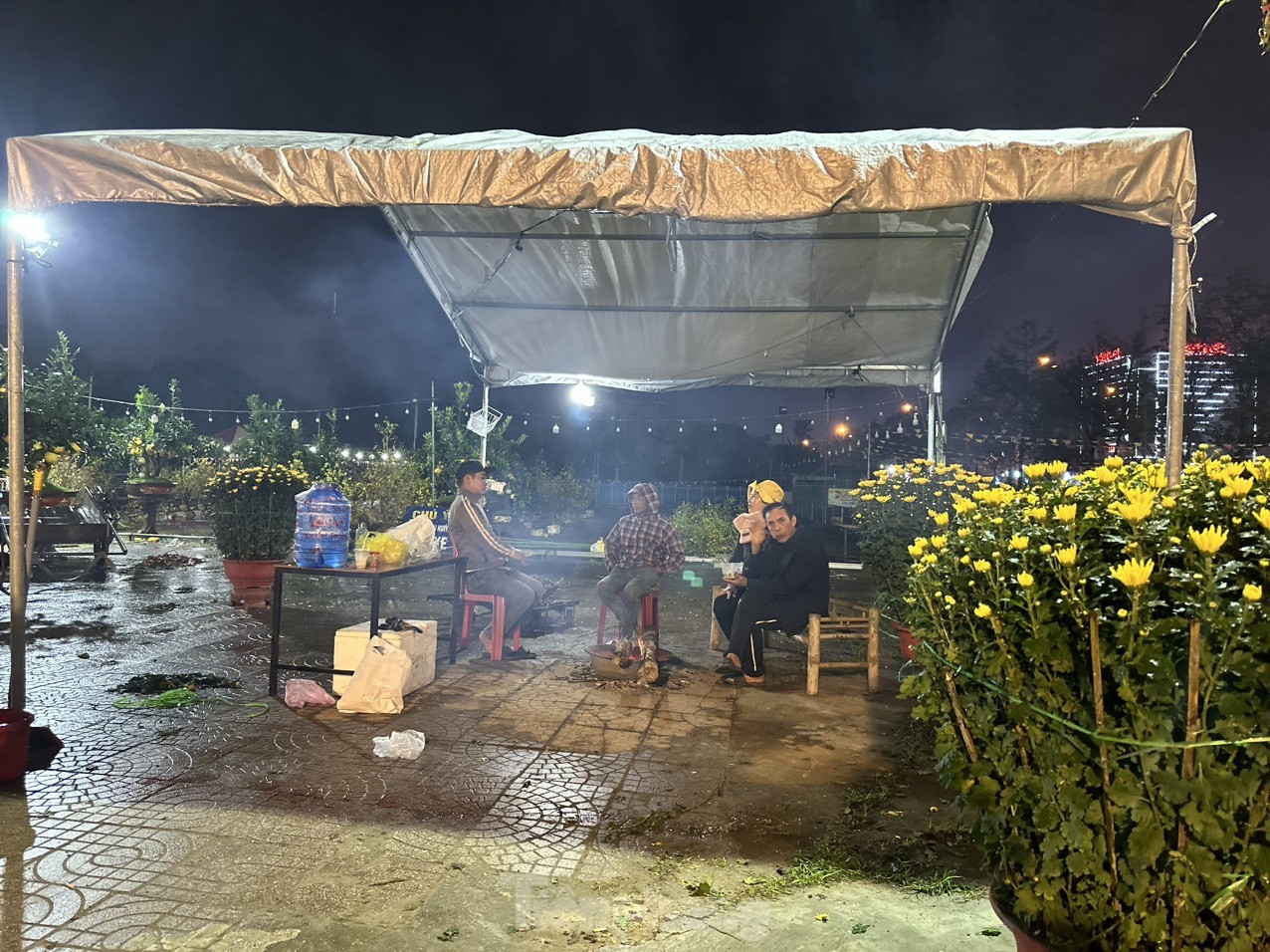 Dù thời tiết có mưa, nhiệt độ giảm, nhưng những tiểu thương vẫn phải co ro trong đêm để bán hoa.