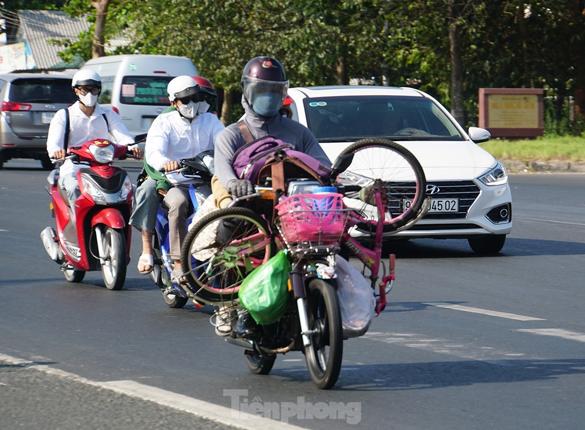 Xe đạp vắt ngang xe gắn máy trên đường quay trở lại TP.HCM làm việc sau Tết. Ảnh: Hòa Hội