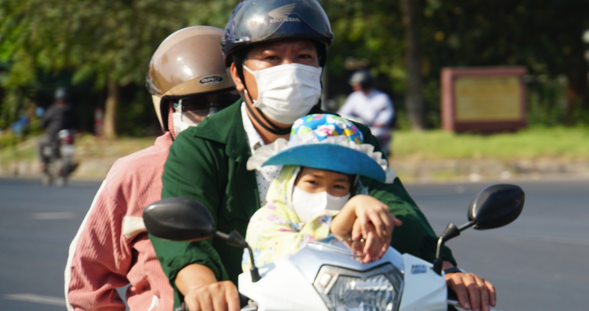 Cả gia đình trên xe gắn máy trên đường. Ảnh: Hòa Hội