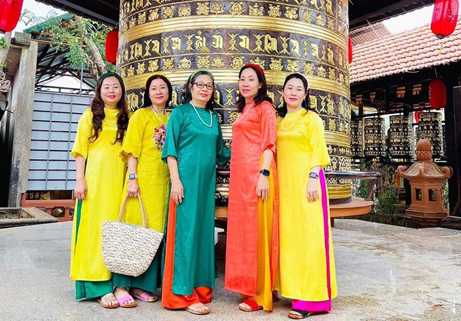 Bà Liên mặc áo dài xanh chụp hình cũng 4 con gái. Ảnh: NVCC.