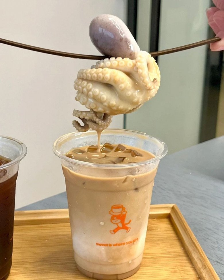 Nếu cà phê thịt heo đã khiến nhiều người ái ngại thì cà phê có hẳn một con bạch tuộc làm... topping thế này càng khiến khách hàng chỉ muốn bỏ của chạy lấy người. Chưa biết uống vào có đau bụng hay không nhưng nhìn topping bóng loáng và như còn sống thế kia thì không rõ có ai dám thử qua.