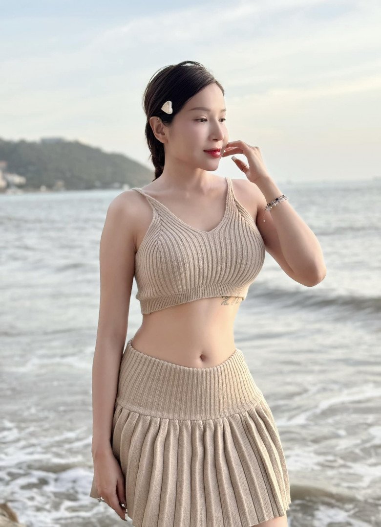 Khả Như đổi mới bằng set đồ mùa hè nhẹ nhàng với áo bra dáng croptop phối chân váy xếp ly dáng ngắn cạp trễ khoe bụng phẳng lỳ.