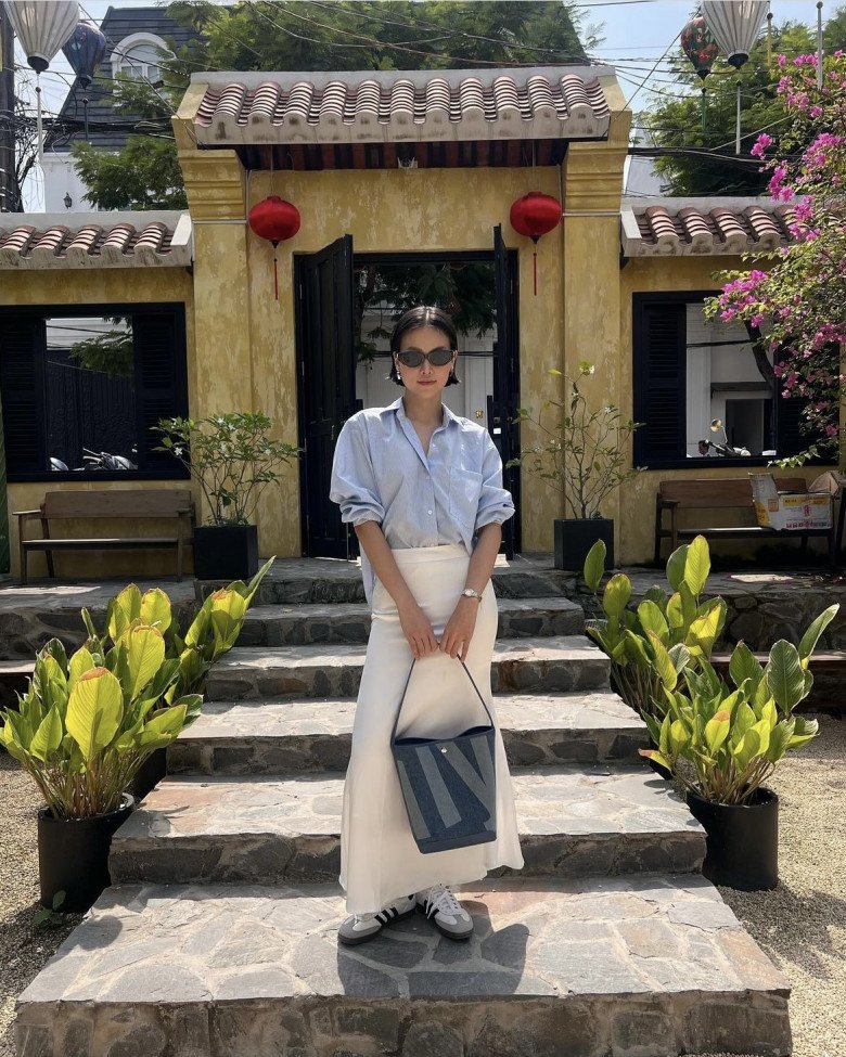 Hoa hậu Phương Khánh kết hợp màu sắc cực hài hòa với áo sơ mi xanh pastel kẻ sọc cùng chân váy suông trắng, thêm đôi giày sneaker cá tính. 