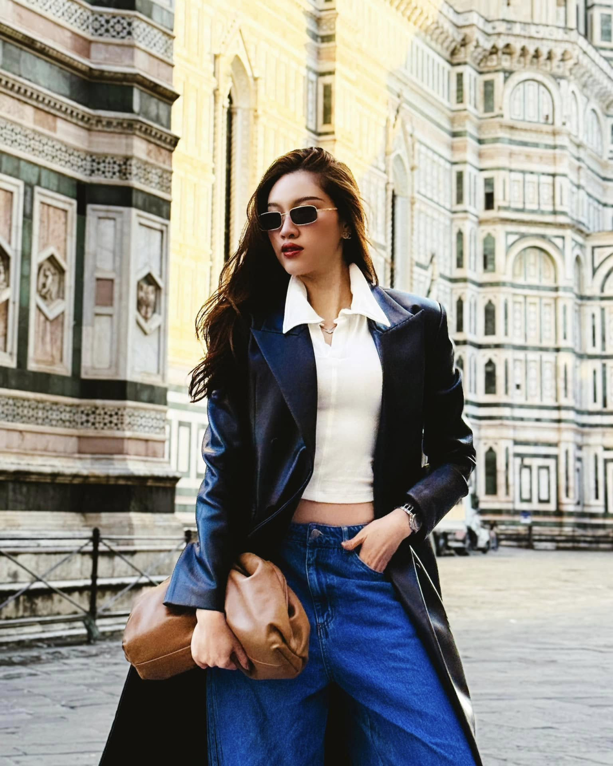 Lúc đó, mỹ nhân sinh năm 1995 phối blazer da cùng áo thun cổ bẻ dáng croptop, quần cạp trễ và xách túi Bottega Veneta để làm điểm nhấn cho trang phục.