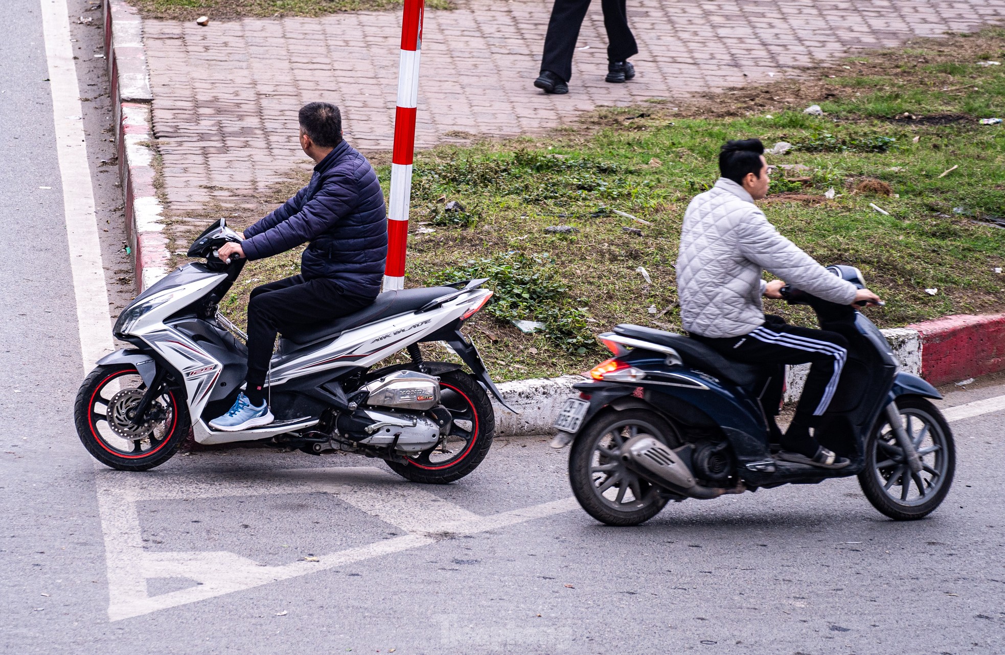 Nhiều người điều khiển xe máy không đội mũ bảo hiểm, đi ngược chiều.