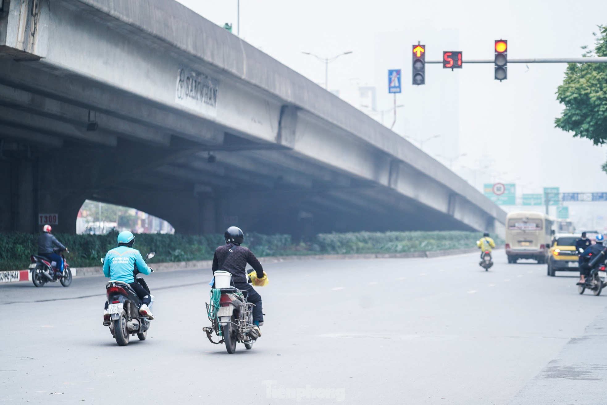 Hai người điều khiển xe máy ngang nhiên vượt đèn đỏ trên đường Phạm Hùng.