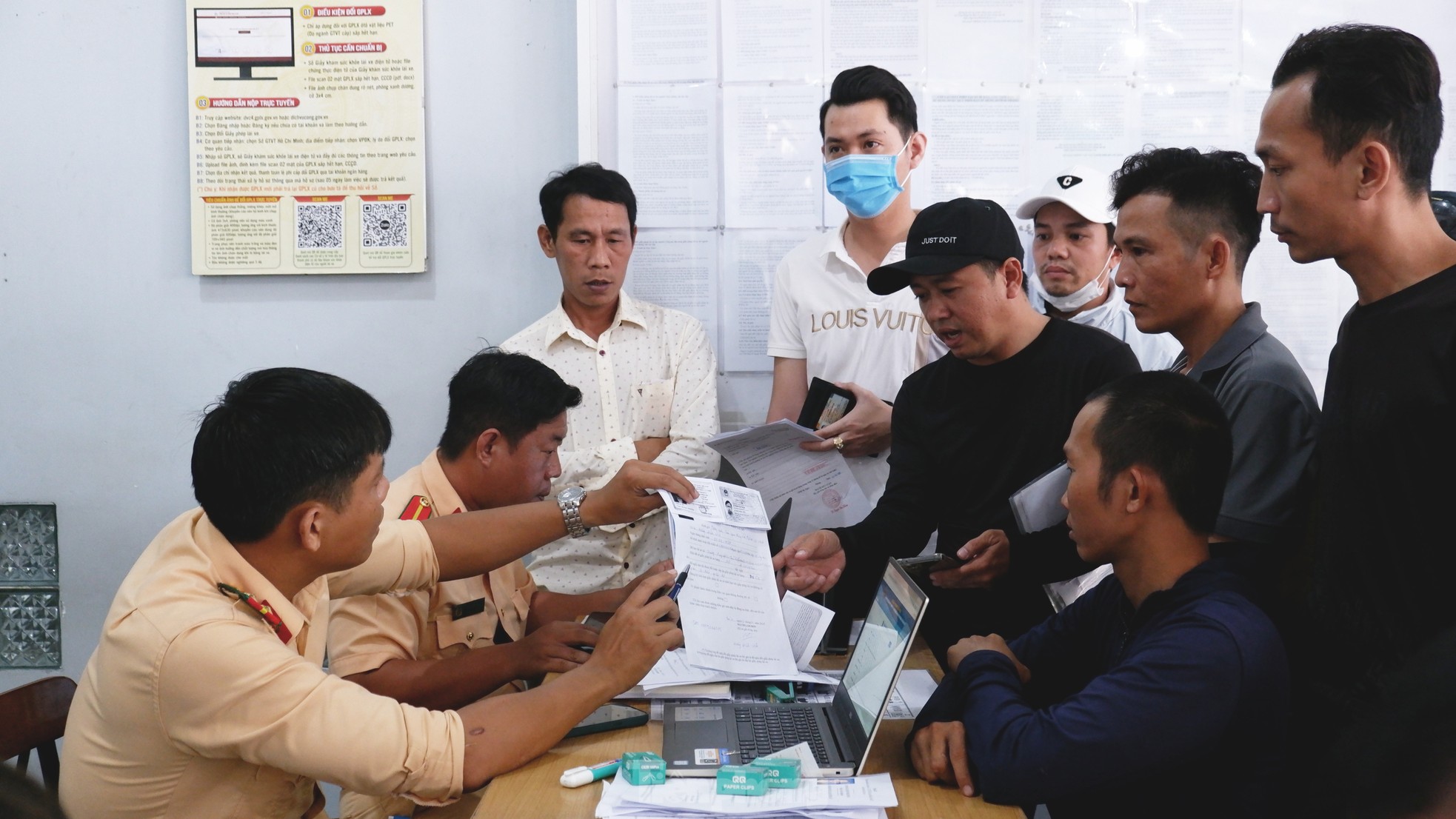 Cán bộ CSGT hướng dẫn người dân làm hồ sơ cấp đổi giấy phép lái xe.