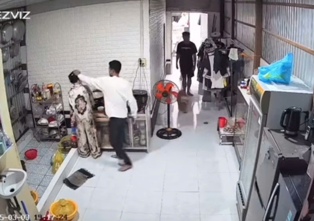 Người phụ nữ bị túm tóc, đánh mạnh vào đầu khi nấu ăn. Ảnh: Cắt từ clip mạng xã hội đăng tải