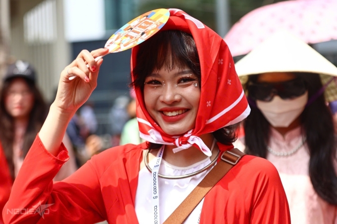 Khán giả nữ trùm khăn, dùng quạt cầm tay che đầu giữa tiết trời nóng.