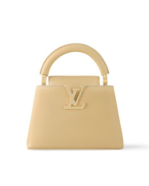 Với tà áo dài dịu dàng, Hoa hậu kết hợp cùng mẫu túi Louis Vuitton Capucines tông màu vàng chanh xinh xắn, giá bán ở Việt Nam 157 triệu đồng. Thiết kế được chế tác từ da sần Taurillon với logo Louis Vuitton tráng men tựa như một món trang sức tinh xảo.