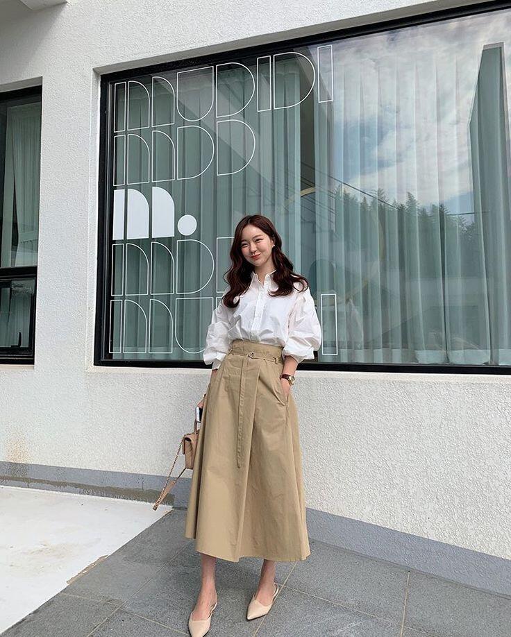 Sự kết hợp giữa áo sơ mi trắng oversized cùng chân váy midi màu be mang đến một vẻ đẹp thanh lịch và tinh tế.