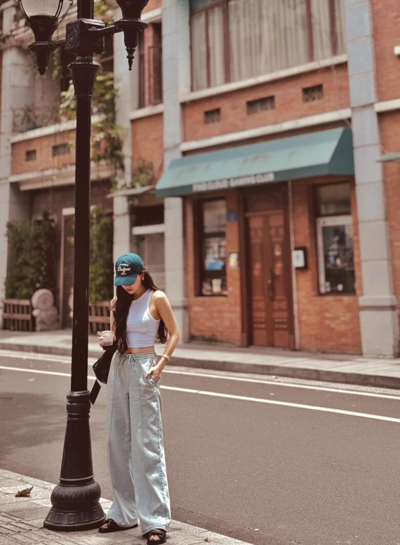 Một phong cách streetwear đầy chất “cool girl” với crop top trắng ôm sát kết hợp quần jeans rộng cạp cao.