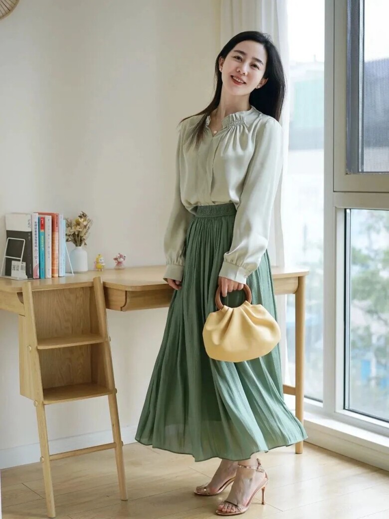 Chiếc áo blouse lụa nhẹ nhàng màu xanh kết hợp cùng chân váy maxi xanh lá tạo nên vẻ đẹp duyên dáng, thanh thoát.