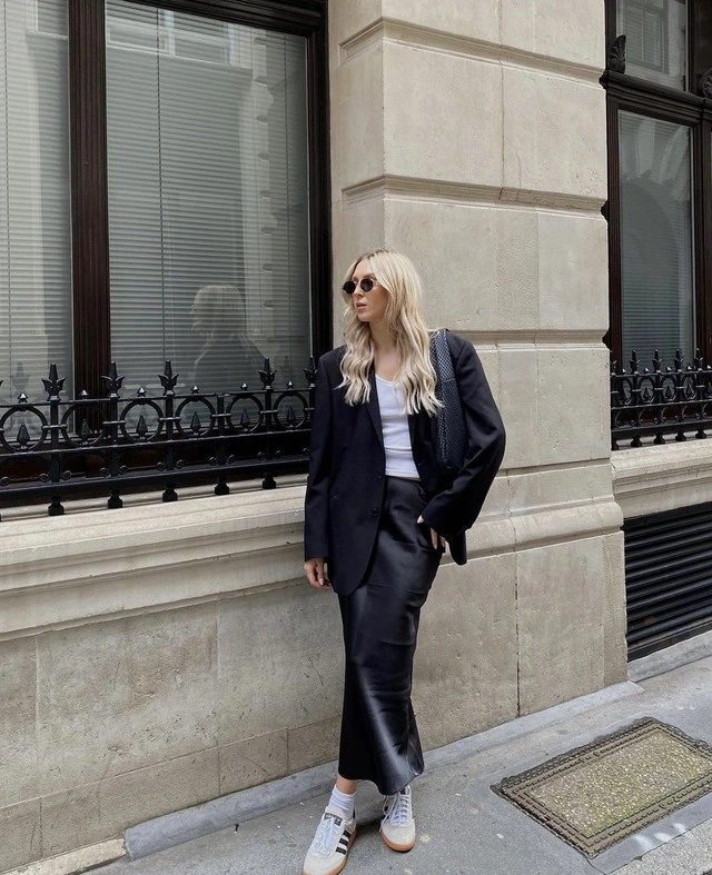 Sự kết hợp giữa blazer oversized và chân váy da midi tạo nên một diện mạo cá tính nhưng vẫn tinh tế. Đôi sneaker mang đến nét trẻ trung, hiện đại, hoàn thiện tổng thể trang phục với tinh thần effortless chic.