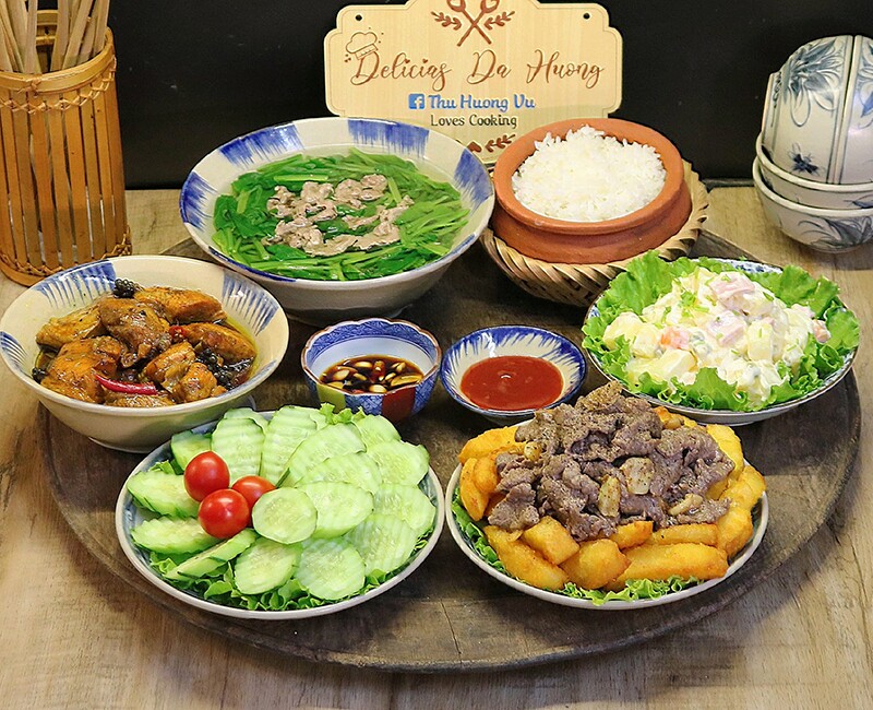 Mâm cơm này có: Thịt bò xào khoai tây chiên, cá kho, canh rau cải thịt bò, salad nga, dưa chuột.