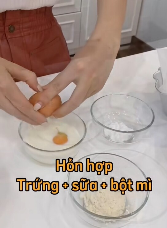 Trộn hỗn hợp sữa, trứng, bột mì. Sau đó xếp khoai lang vào khay đã lót giấy nến, rưới hỗn hợp đã trộn lên. 