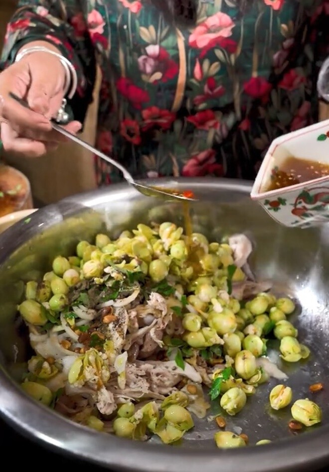 Nữ diễn viên xé gà, cho búp bông sầu riêng vào tô lớn, rưới nước trộn gỏi vào, trộn đều lên là xong. 