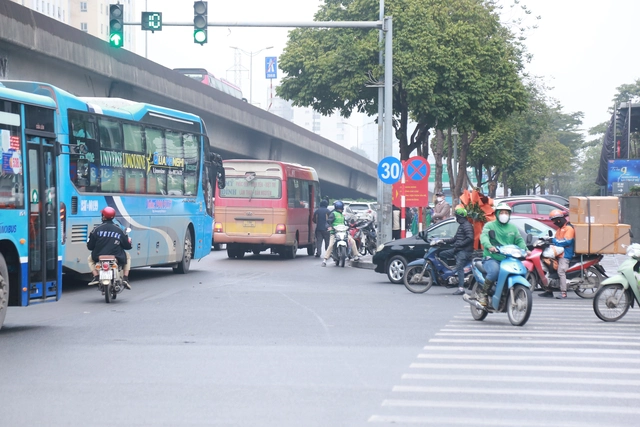 Không chỉ những bất cập trên, theo ghi nhận của PV, một chiếc ô tô chở khách cũng dừng nhận hàng ngay cạnh biển cấm dừng đỗ xe.