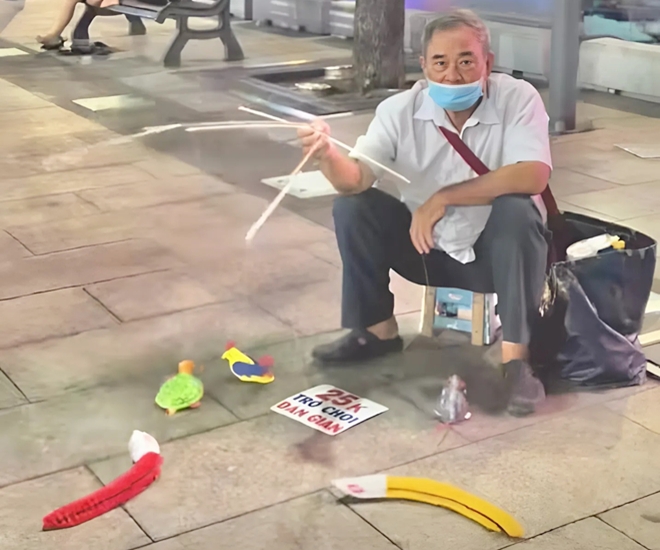 Chú bán những món đồ chơi thủ công truyền thống bên lề đường