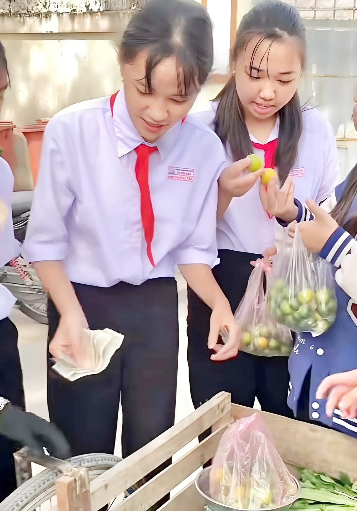 Mỗi bạn học sinh vui vẻ mua giúp bà một món trên xe đẩy còn hàng