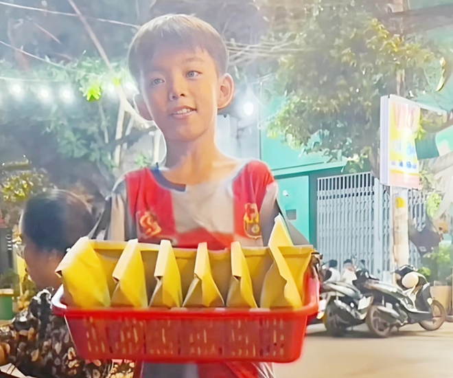 Cậu bé bán hạt dẻ dạo mời khách mua giúp