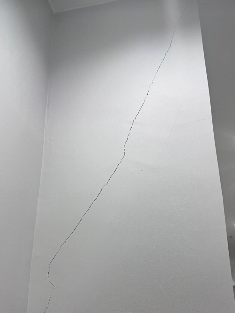 Chị Trinh chụp ảnh vết nứt trong tòa nhà đang sinh sống. Tối qua, chị đã thuê khách sạn bên ngoài để lưu trú để đảm bảo an toàn.