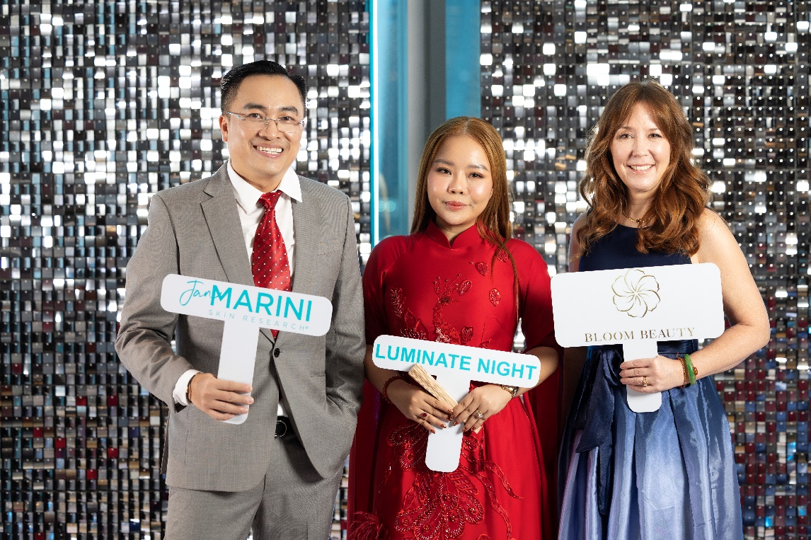 Bác sĩ Trần Nguyễn Như Hương (áo dài đỏ) chụp hình cùng ông Thái Bình Minh - Founder amp; CEO công ty Bloom Beauty và bà Amiee DeMarais – Giám đốc kinh doanh quốc tế cấp cao của Jan Marini – Skinsolutions.