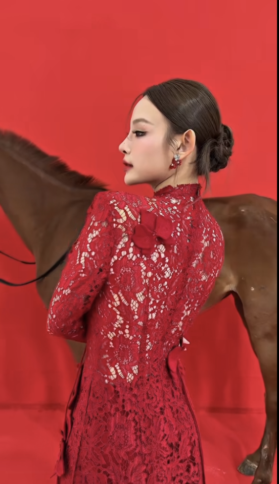 Huyền Baby gây ấn tượng khi chọn áo dài ren đỏ, phông nền màu đỏ - gam màu thường được lựa chọn trong dịp đầu năm bởi mang ý nghĩa may mắn, thịnh vượng và khởi đầu thuận lợi.