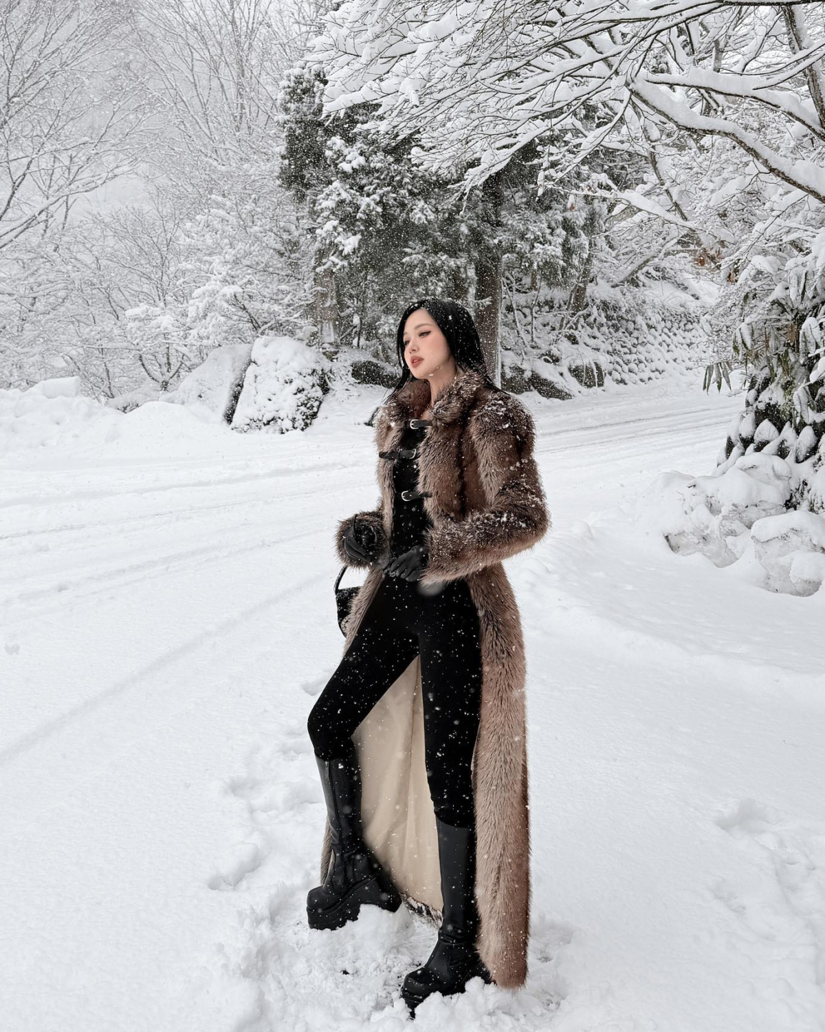 Đi ngắm tuyết trắng ở Nhật Bản, Tâm Tít diện phong cách sang chảnh với áo lông dài chấm đất. Bên trong cô phối cả cây đồ đen cool ngầu.
