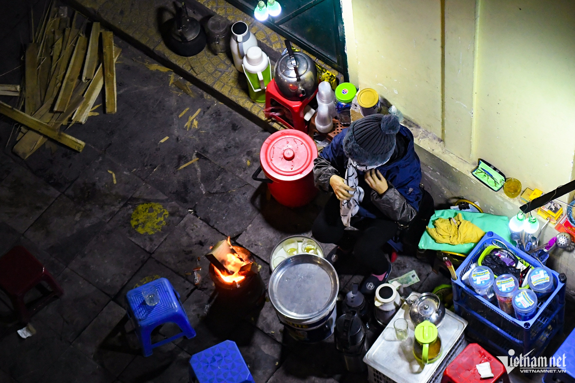 Ở gần khu vực cầu Chương Dương, bà Nguyễn Thị Hoàn trong khi ngồi bán hàng nước phải quấn thêm chiếc khăn lên cổ cho ấm. Hôm nay bà mang thêm gỗ tạp để đốt, giúp khách sưởi ấm.