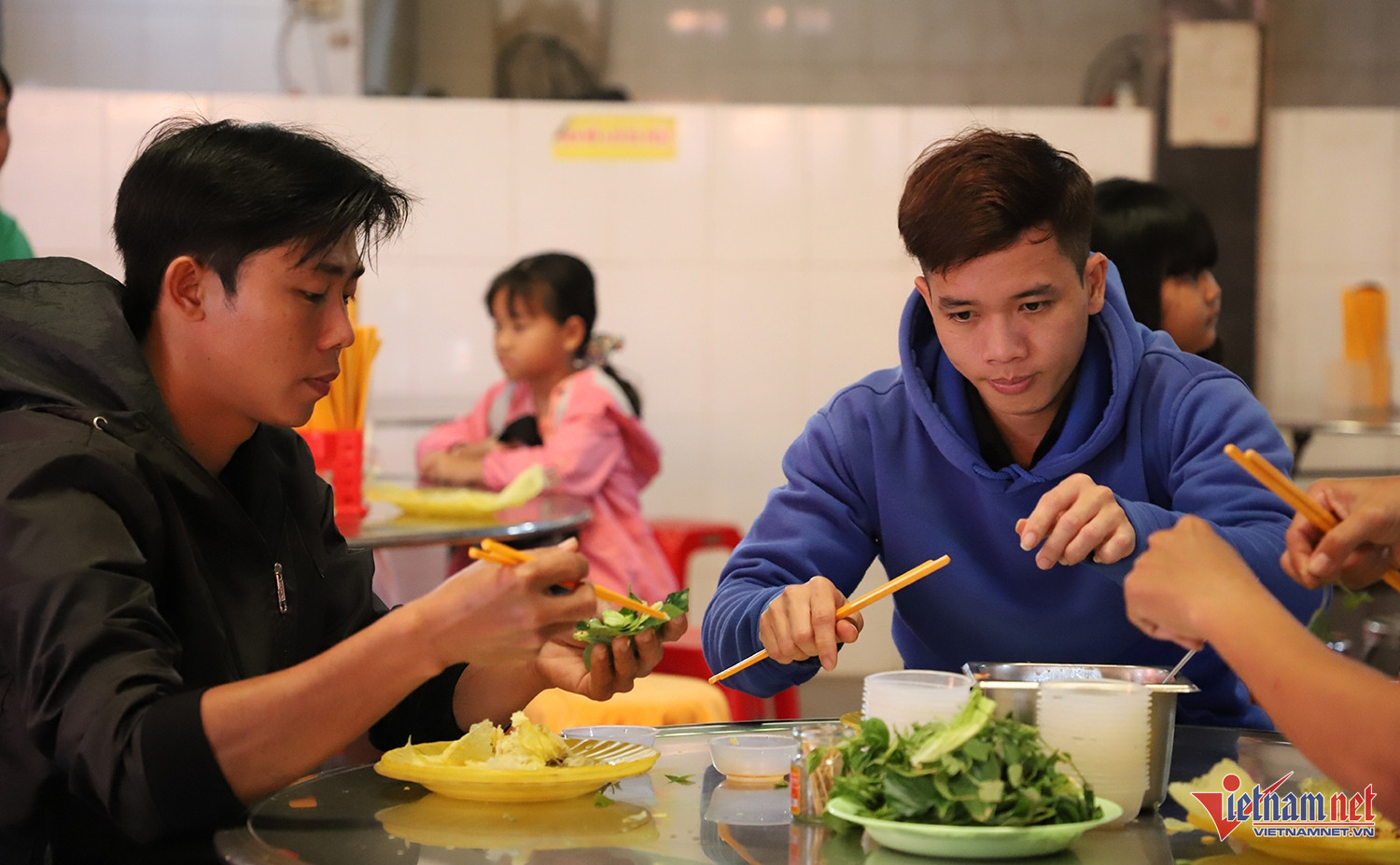 Anh Nam (bìa trái) cùng bạn thưởng thức món bánh xèo vàng ươm, giòn rụm